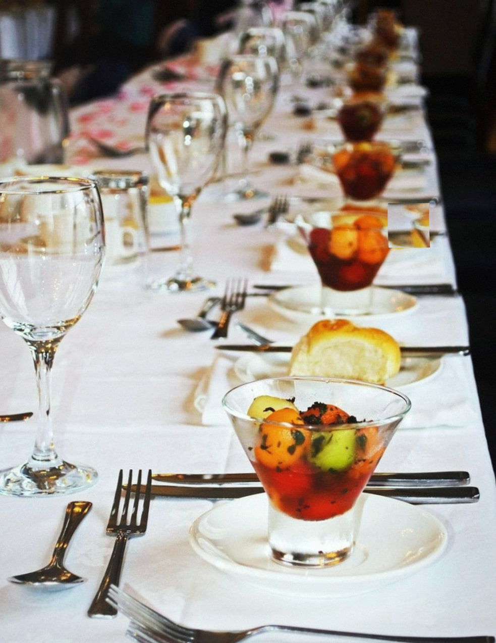 Long shared table in a barn with festoon lights